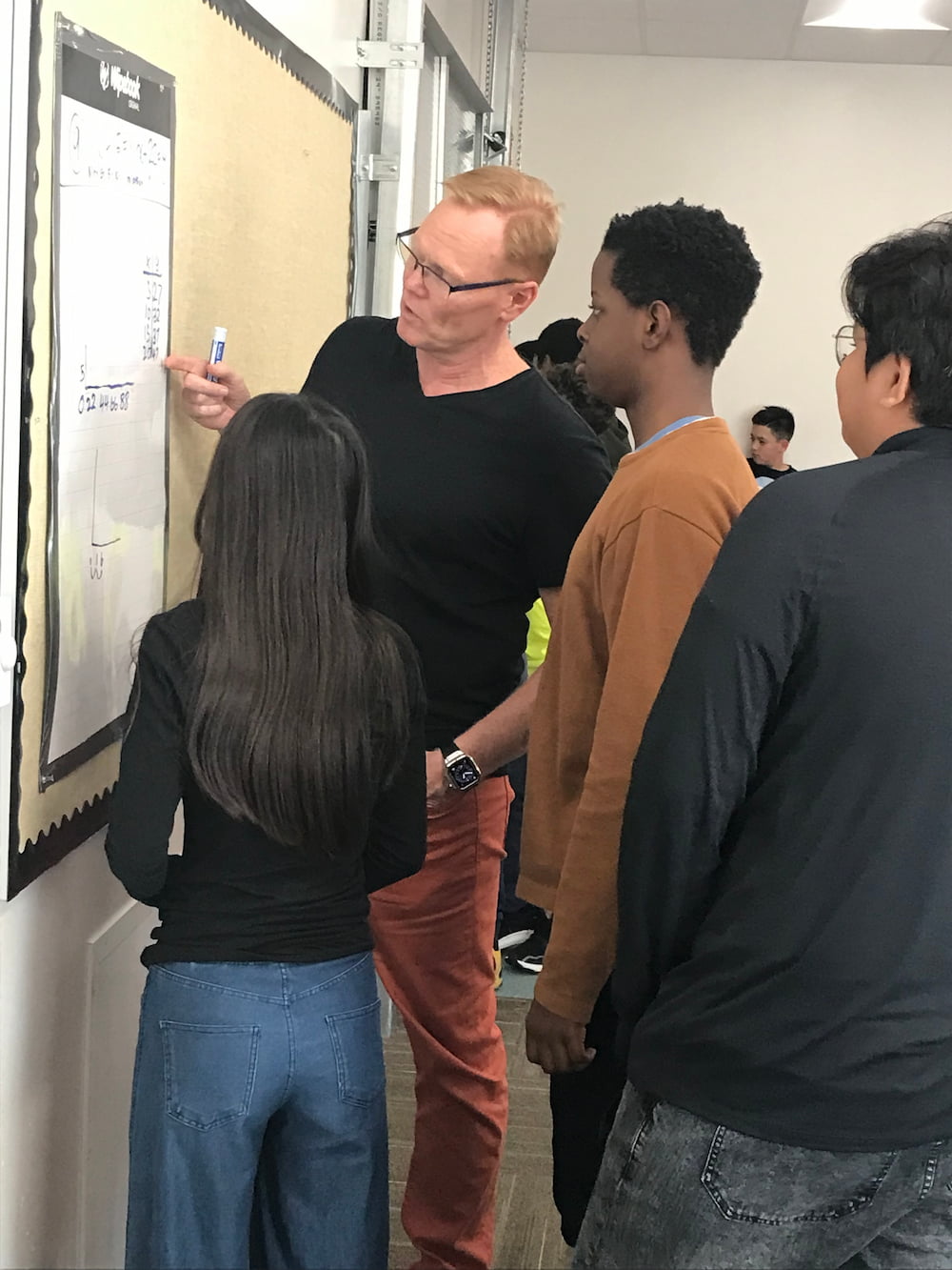 Students working at vertical whiteboards